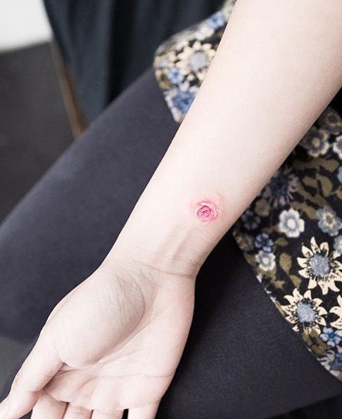 A subtle and lovely pink rose tattoo