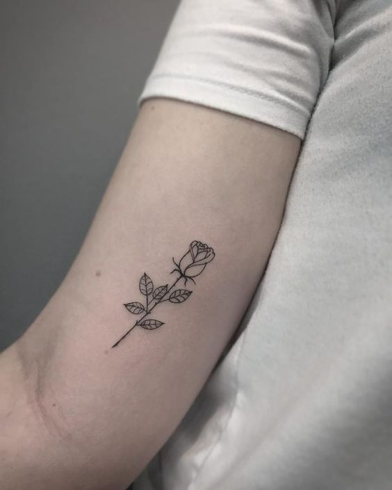 Small black rose tattoo on inner arm