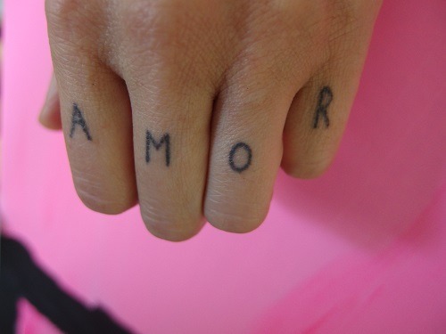 AMOR finger tattoo