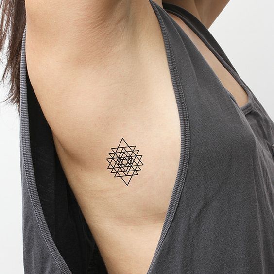 Black triangle tattoo on the ribcage