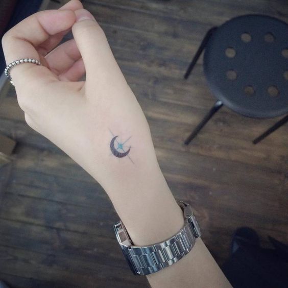 Crescent moon and star tattoo on the hand