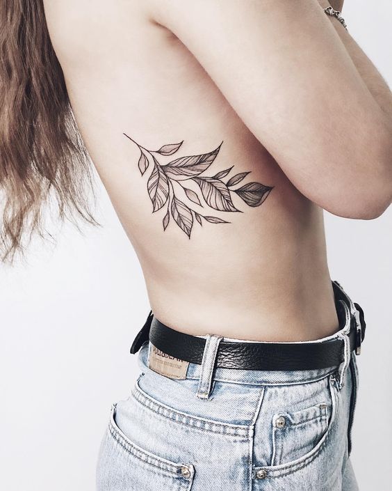 Delicate black flower tattoo on the rib