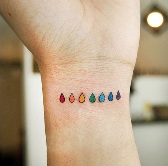 Dew drops rainbow colors LGBT tattoo on the wrist