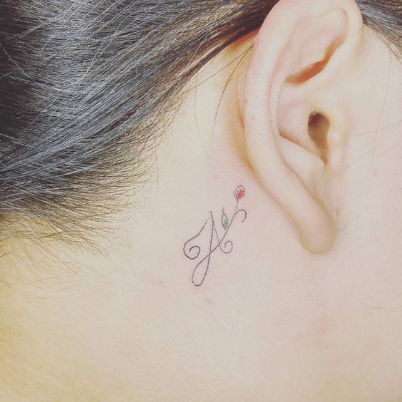 Initial tattoo behind the ear