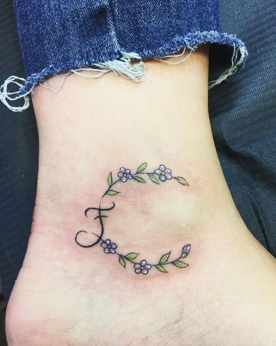 Initial tattoo on an ankle