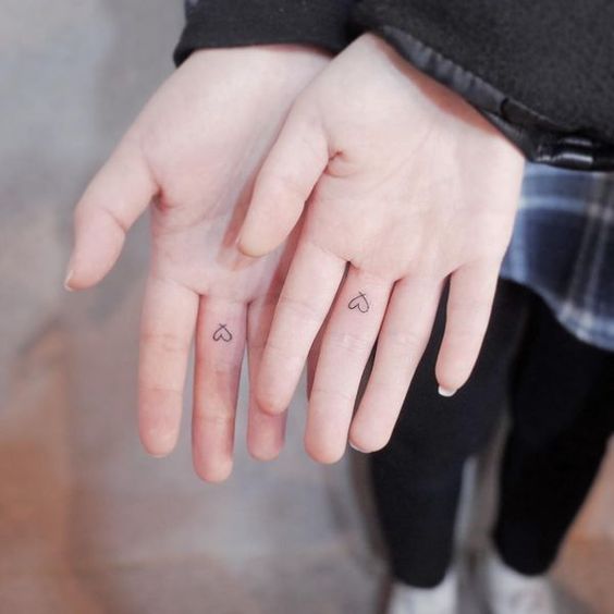Matching heart tattoo on fingers
