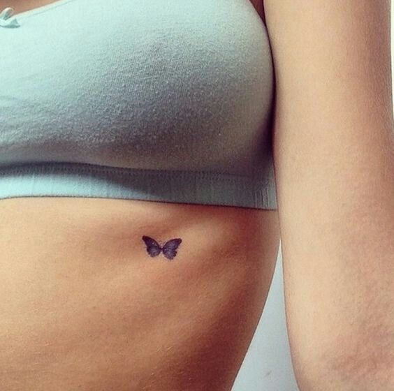 Minimal butterfly tattoo on the ribcage
