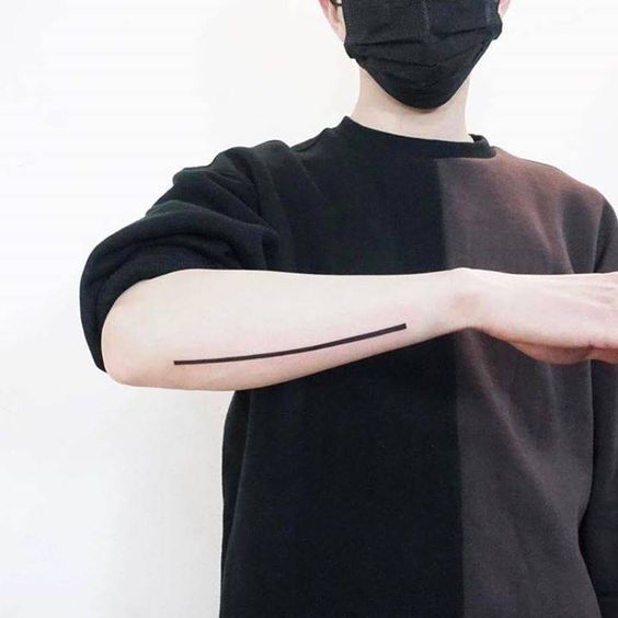 Minimal line tattoo on the right forearm.