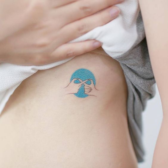 Minimalist style tattoo on the rib cage