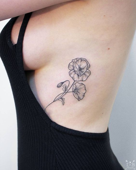 Poppy tattoo on the rib by Irene Bogachuk