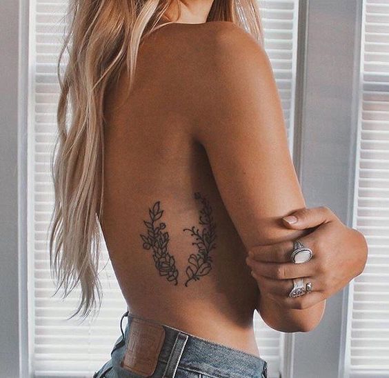 Subtle botanical tattoo on the right rib
