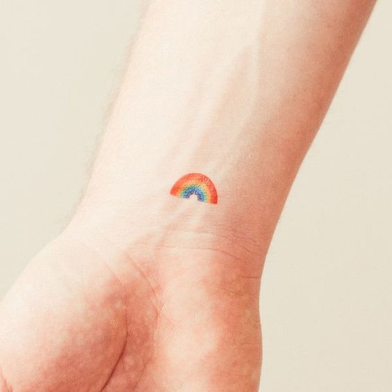 Super cute and small rainbow tattoo on the wrist