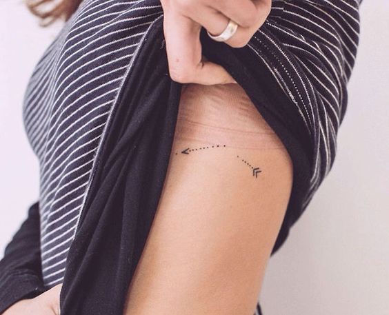 Tiny broken arrow tattoo on the left rib