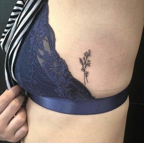 Tiny flower tattoo on the rib