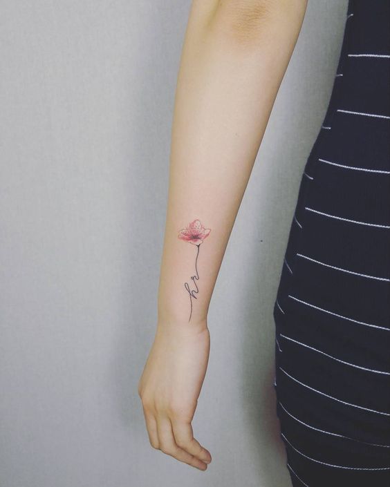 Tiny initials tattoo with a flower