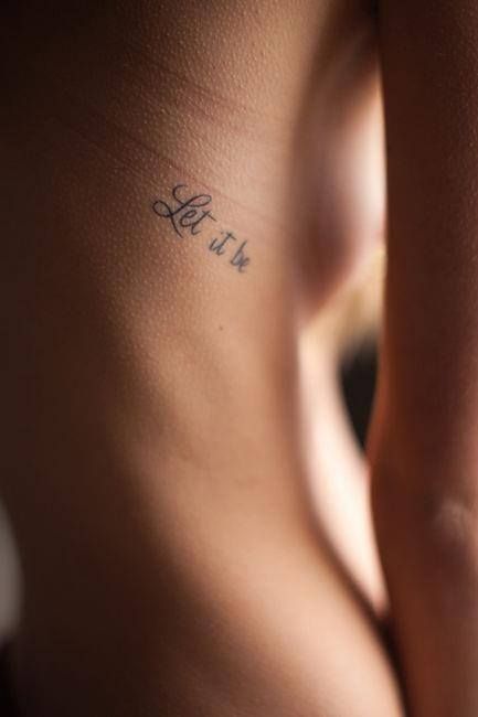 Tiny tattoo on the rib saying Let it be
