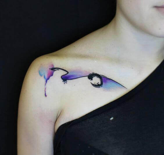 Abstract watercolor tattoo on the collarbone