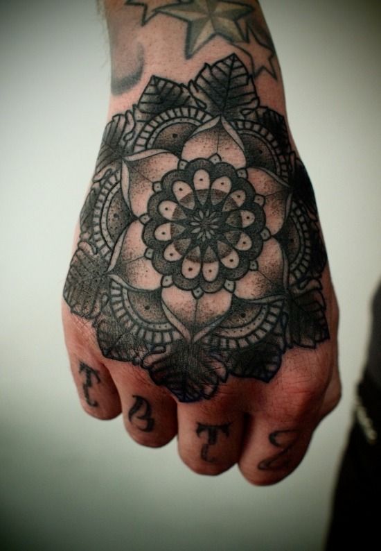 Black mandala tattoo on the hand