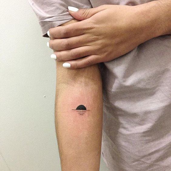 Black sunset tattoo on the inner arm