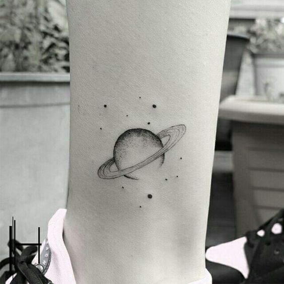 Black tattoo of a Saturn and its moons