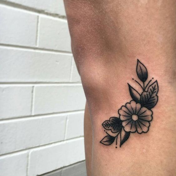 Black traditional flower tattoo on the leg