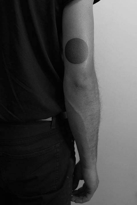 Blackwork simple circle tattoo on the arm