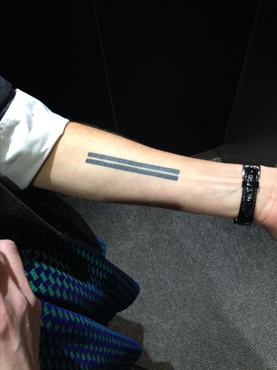 Bold and thick lines tattoo aligned together on the arm