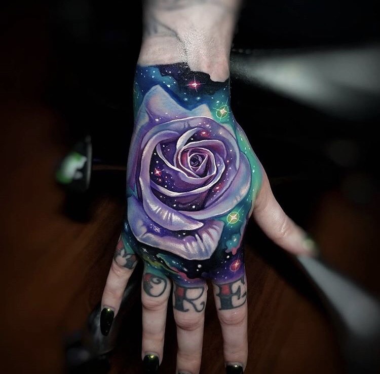 Cosmic style rose tattoo on the hand