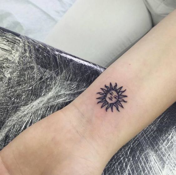 Cute sun with a face tattoo on the wrist