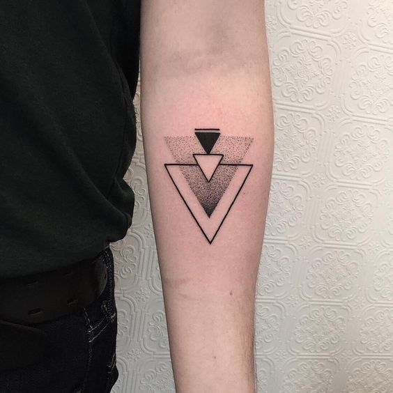 Four small triangles tattoo on the arm