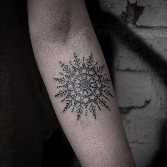 Gentle snowflake-like mandala tattoo on the arm