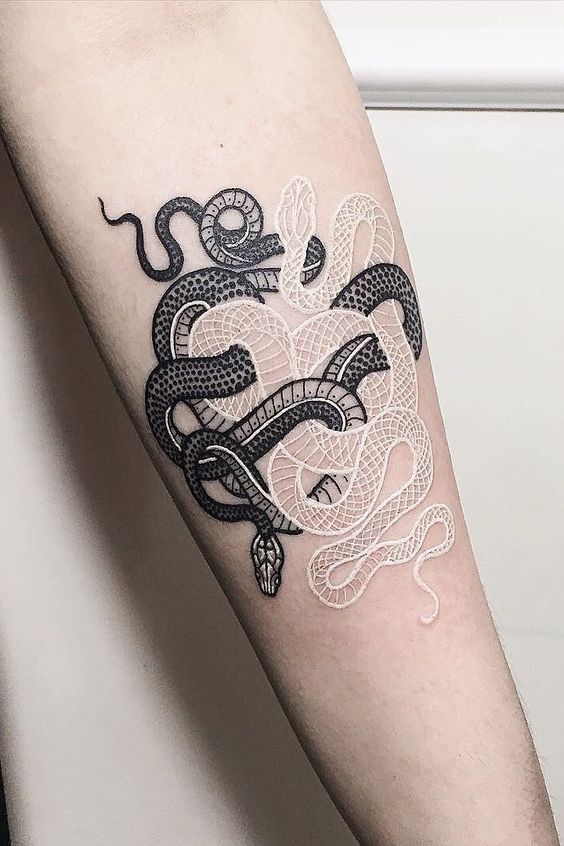 Intertwined black and white snake tattoo