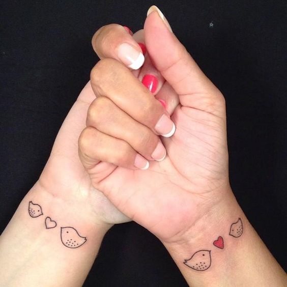 Matching heart tattoos with cute birds on wrists