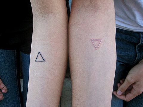 Matching minimal triangle tattoos on arms