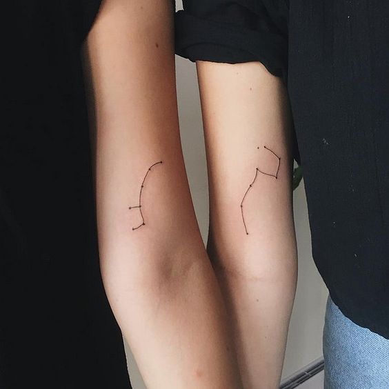 Matching mother and daughter constellation tattoos on arms