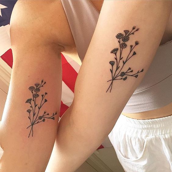 Matching wildflowers tattoo on the arms