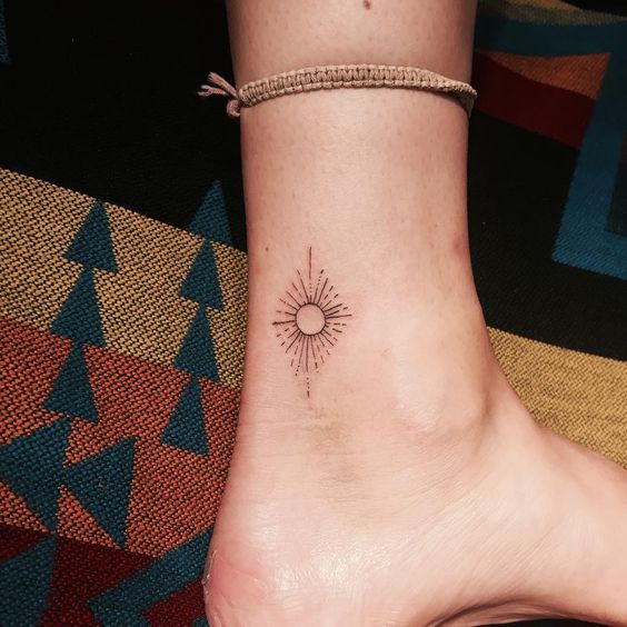 Minimal sun tattoo on the ankle