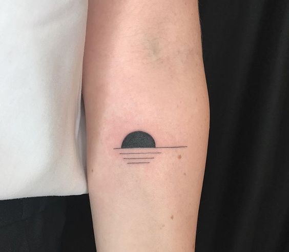 Minimal sunset tattoo on the inner arm