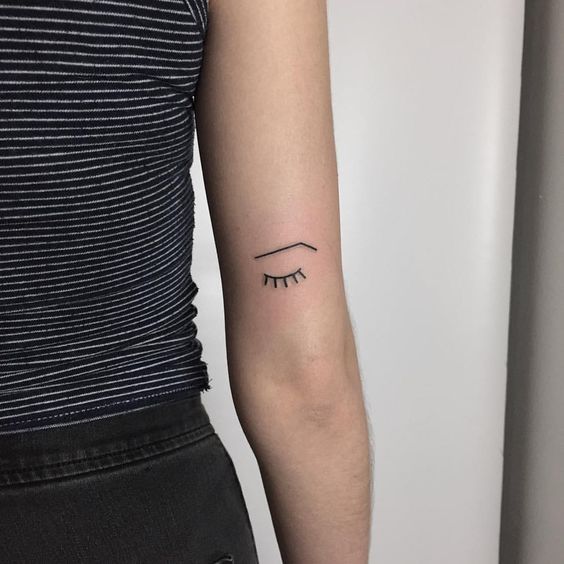 Minimalist eye tattoo on the arm