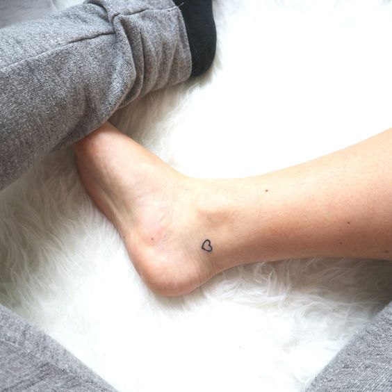 Minimalist heart tattoo on the inner ankle