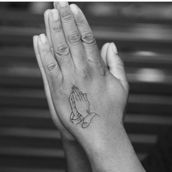Praying hands outline tattoo on the left hand