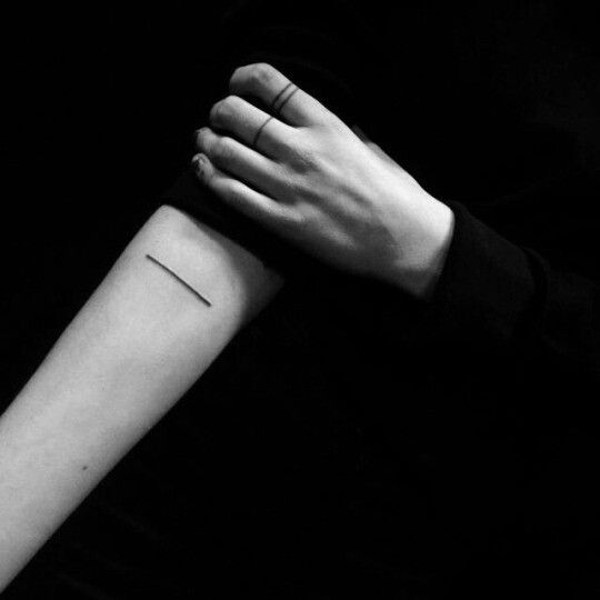Short black line tattoo on the inner arm