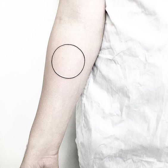 Simple black circle tattoo on the arm