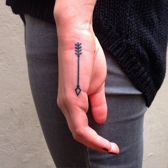 Small arrow tattoo on the hand by Aivaras Lee