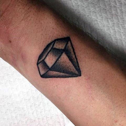 Small black outline shaded diamond tattoo on the wrist