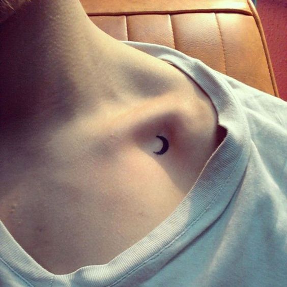 Small crescent black moon tattoo on the clavicle