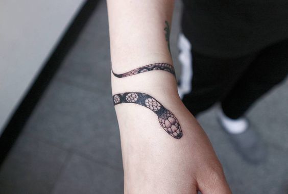 Small snake tattoo around the wrist