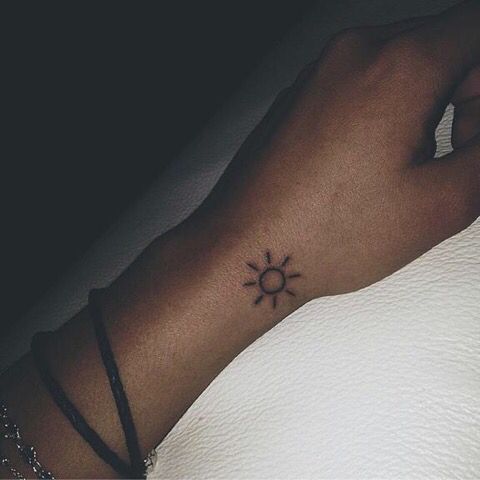 Small sun tattoo on the wrist