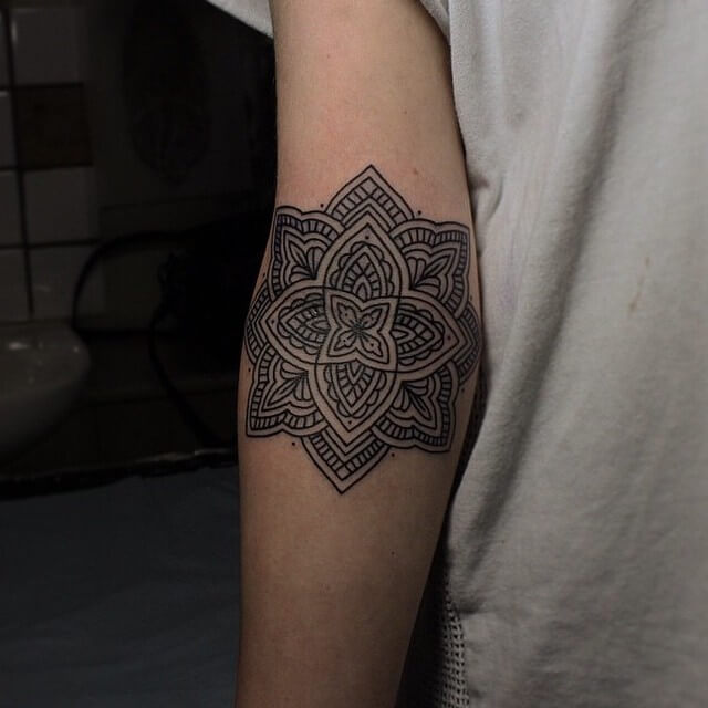 Solid black mandala tattoo on the inner arm