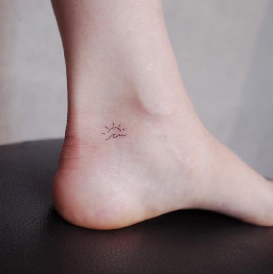 Super tiny and cute sun over the wave tattoo on an ankle